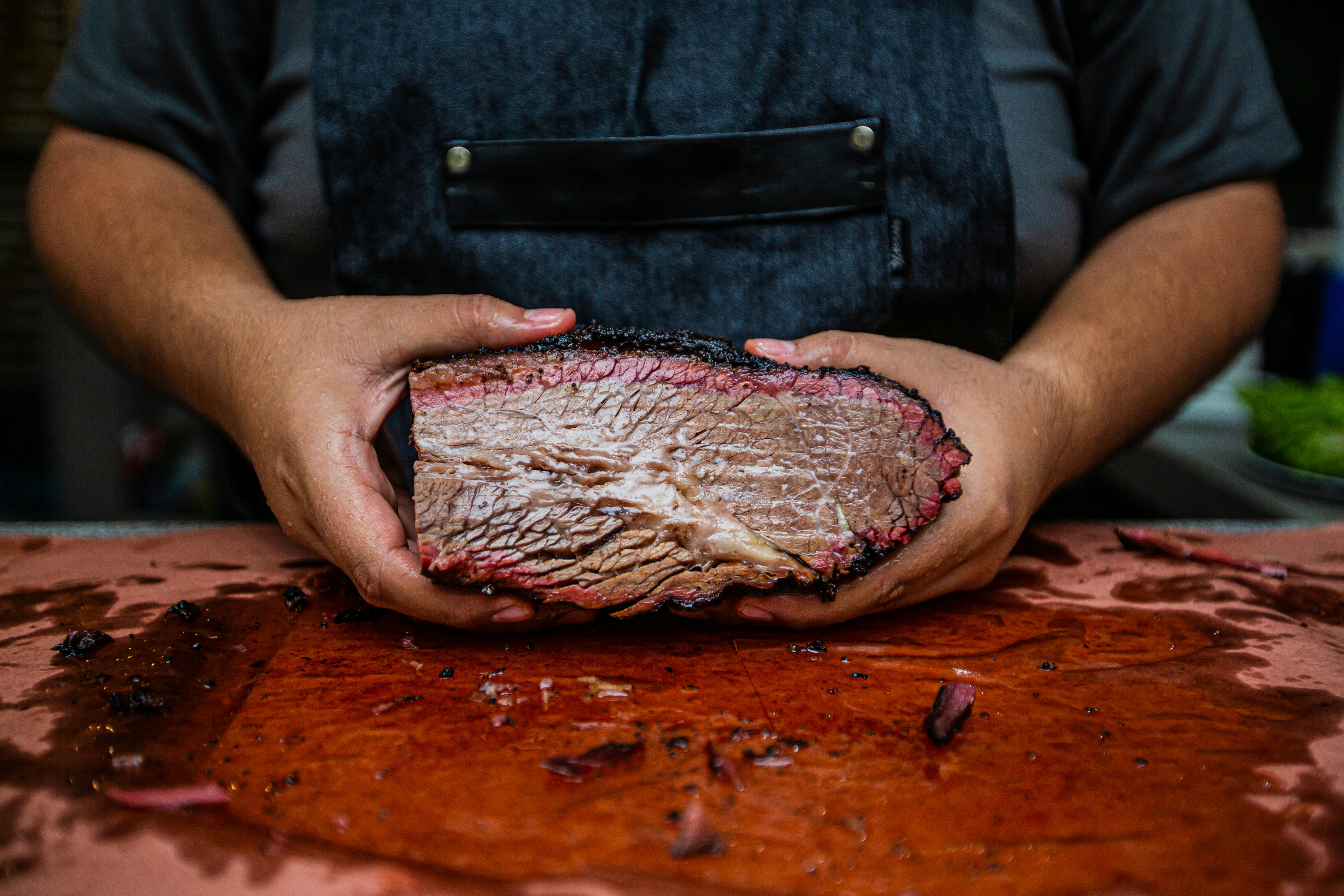 smoked beef brisket cut held by chef